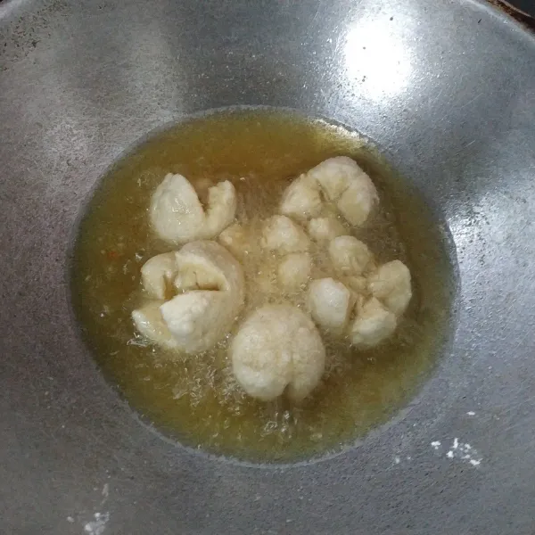 Belah bakso menjadi 4 bagian dan jangan sampai terputus. Panaskan minyak goreng secukupnya, dan goreng bakso hingga matang.