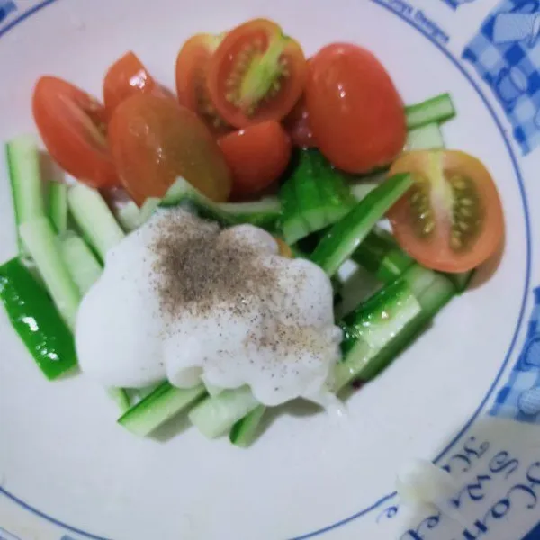 Potong-potong timun dan belah 2 tomat ceri. Masukan ke dalam mangkuk, lalu tambahkan mayonnaise, air lemon, garam, dan lada hitam bubuk. Aduk rata dan sisihkan.
