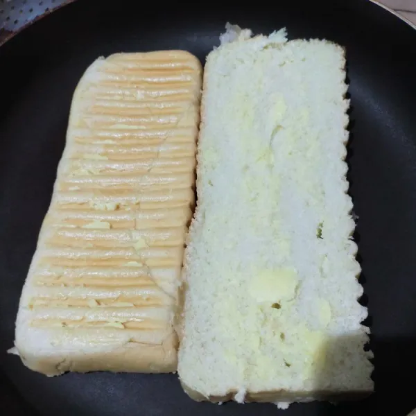 Belah 2 roti kadet. Oles tiap permukaannya dengan mentega/margarin. Panaskan wajan rata, kemudian panggang roti secara bolak-balik hingga kecoklatan.