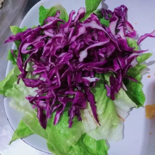 Sobek-sobek daun Romain, kemudian iris tipis kol ungu. Sisihkan.