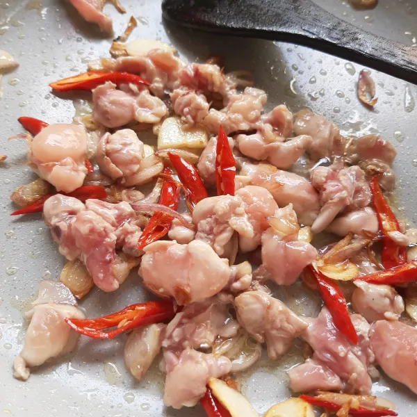 Masukkan cabai merah, tumis sebentar. Masukkan daging ayam, masak sampai ayam berubah warna.