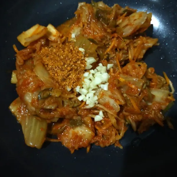 Panaskan wajan, masukan kimchi, gochugaru dan bawang putih cincang. Masak dengan api kecil 5-7 menit hingga kimchi layu.
