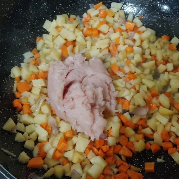 Masukan wortel, kentang aduk hingga merata, masukan daging ayam giling aduk hingga tercampur tambahkan air sedikit agar sayuran cepat empuk.
