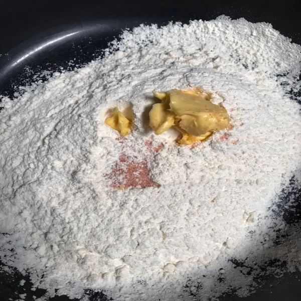 Tuang mentega di atas tepung terigu kemudian di uleni sampai kalis setelah kalis dikasih 2-3sdm minyak sayur lalu diamkan adonan selama 45 menit.