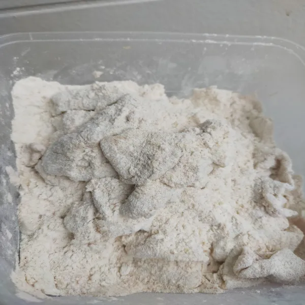 Balurkan kulit ayam yang sudah lengket dengan tepung basah ke adonan kering 1 per satu sampai semua bagian rata tertutupi dengan adonan tepung kering.
