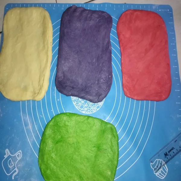 Kemudian gilas masing-masing adonan kira-kira menjadi ukuran 20cm x 15cm. Lalu taruh adonan putih paling bawah, selanjutnya tumpuk adonan berwarnanya, kombinasi warna sesuai selera masing-masing.