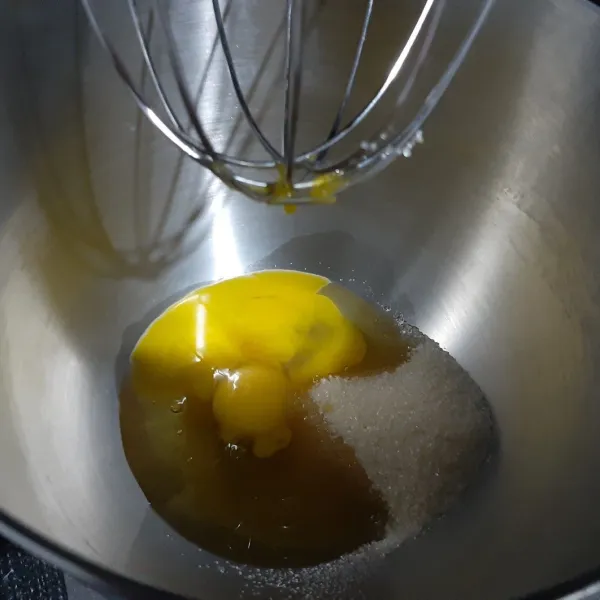 Dalam wadah, masukkan telur dan gula pasir. Lalu, kocok dengan kecepatan tinggi sampai mengembang.