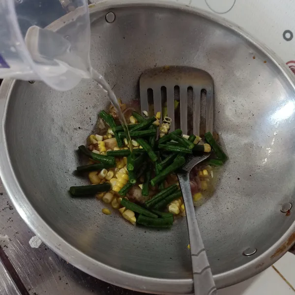 Masukkan kacang panjang dan jagung, lalu tambahkan air, tunggu sampai jagung matang.