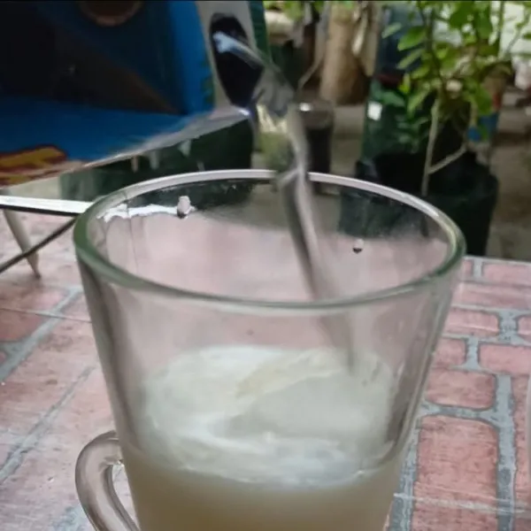 Tuang air kelapa ke dalam gelas.
