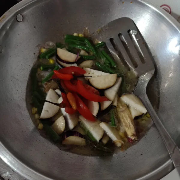 Masukkan terong dan tomat, aduk rata, bumbui dengan lada, gula, garam, dan kaldu jamur.