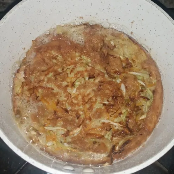 Panaskan pan, tuang minyak agak banyak supaya nanti hasilnya lebih krispi. buat dadar. Masak hingga semua sisinya matang, angkat dan sisihkan.