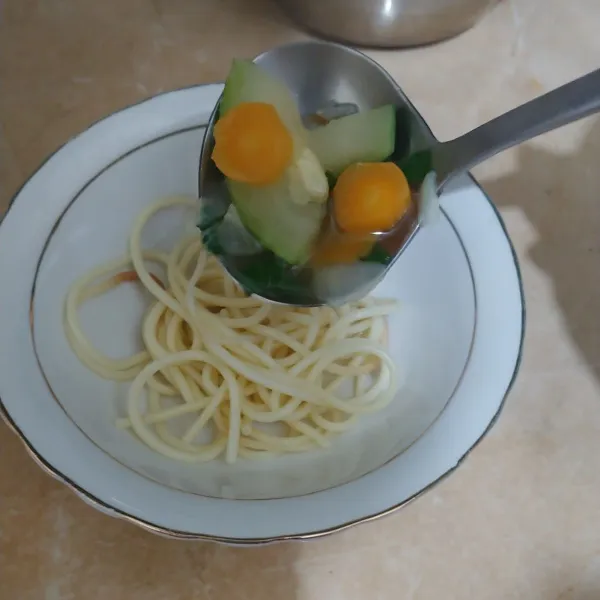 Tata spaghetti di mangkuk, tuang sup dan sajikan.