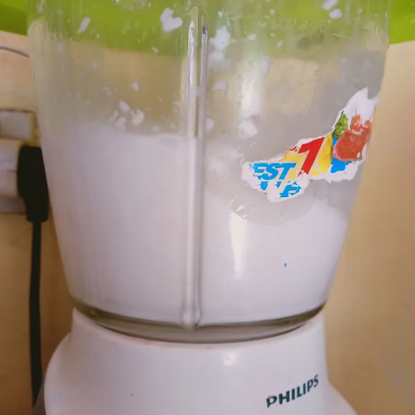 Blender kelapa yang sudah di iris tipis dengan segelas air minum.