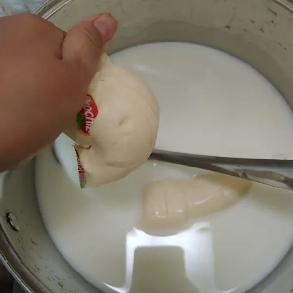 Untuk membuat vla kejunya, tuang susu ke dalam panci. Masukkan keju oles masak sambil terus di aduk sampai keju larut.