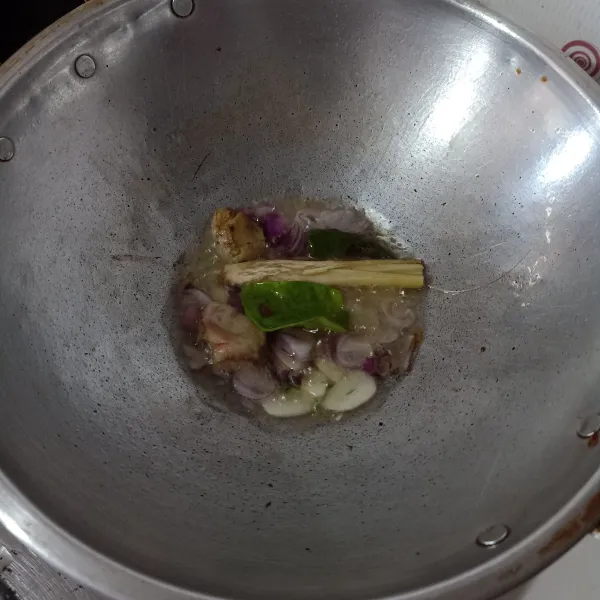 Tumis bumbu iris dan rempah sampai harum.