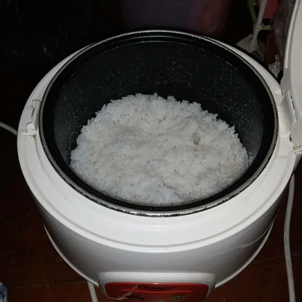 Cuci bersih beras kemudian masak dengan menggunakan rice cooker hingga matang.