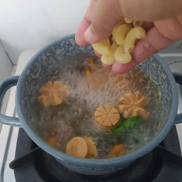 Tambahkan air, setelah mendidih masukkan seledri, makaroni rebus dan sosis.