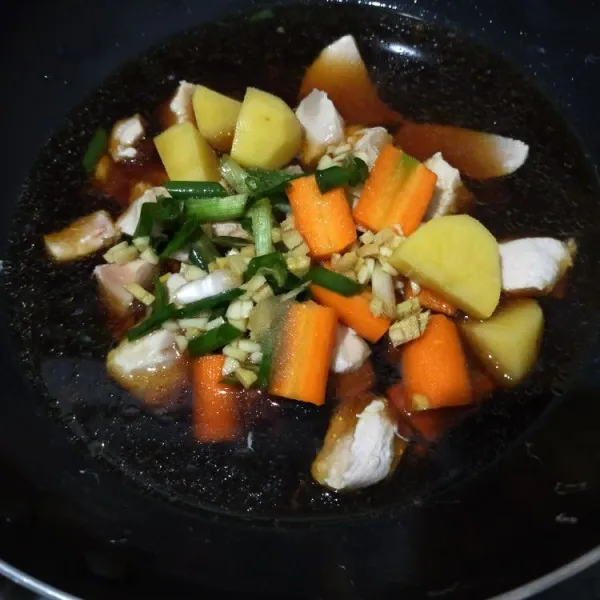 Setelah 15 menit buang air ayam. Letakkan ayam di wajan tanpa minyak. Masukkan wortel, kentang dan bahan bumbu. Masak dengan api kecil hingga mendidih. Cicipi rasanya.