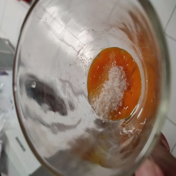 Masukkan kuning telur, gula, vanili, serta garam ke dalam gelas.