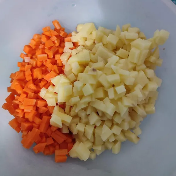Kupas kulit kentang dan wortel, kemudian potong dadu, sisihkan.
