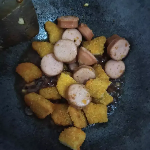 Kemudian masukkan sosis dan nugget. Aduk sebentar, lalu matikan kompor. Letakkan di piring dan taburi dengan daun bawang yang sudah di iris. Siap dinikmati.