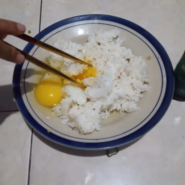 Campurkan telur mentah dan nasi, kemudian aduk hingga rata.