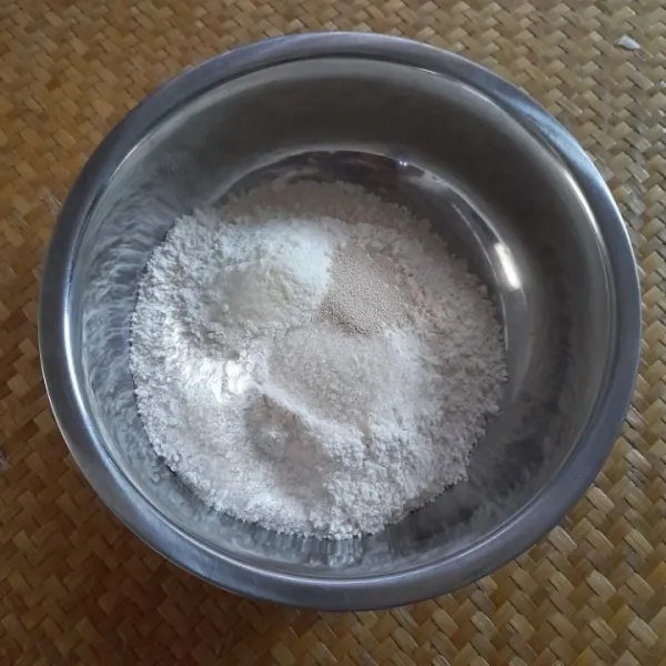 Siapkan wadah, masukkan tepung terigu, gula, ragi dan susu bubuk, aduk hingga rata.
