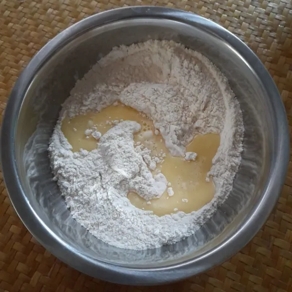 Tambahkan bahan cair yang telah dicampur jadi satu, lalu uleni adonan hingga setengah kalis.