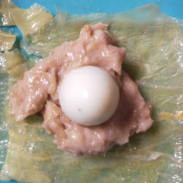 Kemudian masukkan 1/2 sdm adonan, dan beri telur puyuh diatasnya. Bentuk hingga menutupi telur puyuh.