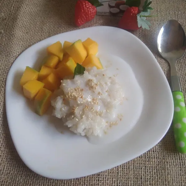 Ambil secukupnya ketan, beri potongan buah mangga. Siram dengan kuah santan dan taburi wijen sangrai. Sajikan.
