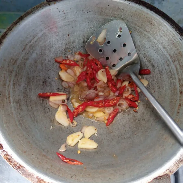 Tumis bawang merah, bawang putih, cabai merah keriting dan cabai rawit sampai harum dan layu.