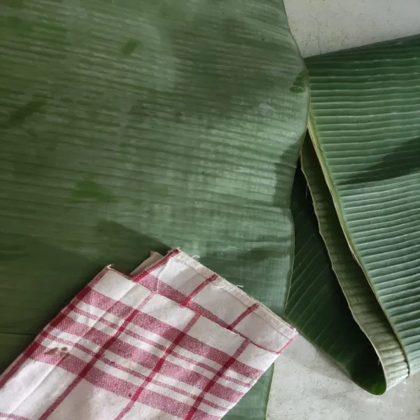 Lap bersih daun pisang yang akan digunakan sebagai pembungkus, siapkan juga tusuk giginya.