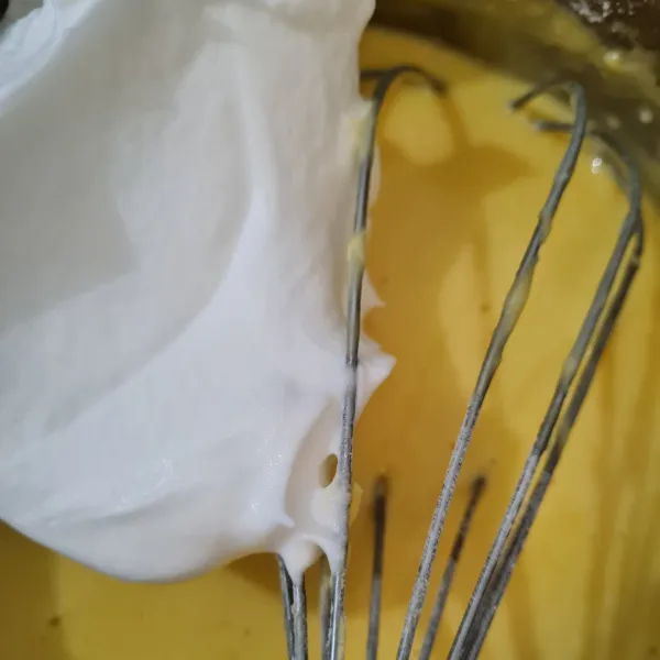 Ambil secukupnya kocokan merengue. Masukkan ke dalam adonan kuning telur. Aduk sampai semua tercampur rata.  Kemudian tuang ke dalam sisa adonan merengue. Aduk lipat merata