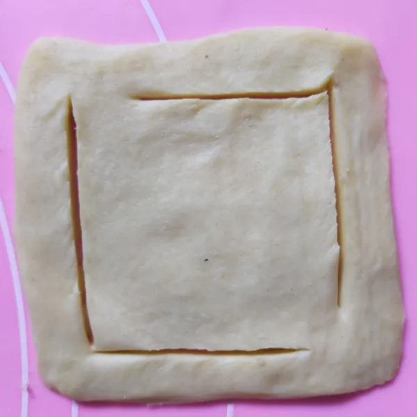Lebarkan pastry, lalu lipat ke dalam dari arah kedua ujung. Lalu tumpuk dan iris kira kira ketebalan 2 cm, dan potong persegi dengan ukuran 12 x 12 cm. Bentuk garis di setiap tepinya.