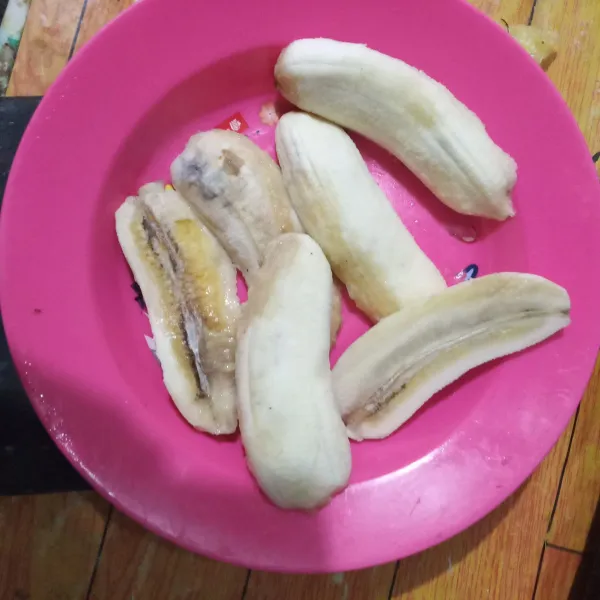 Kupas pisang, lalu belah menjadi 2 bagian.