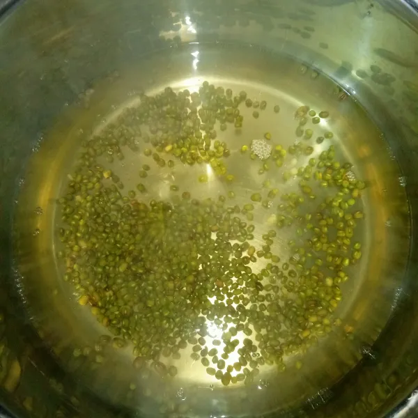 Didihkan air, rebus kacang hijau yang sudah dicuci bersih hingga setengah matang.