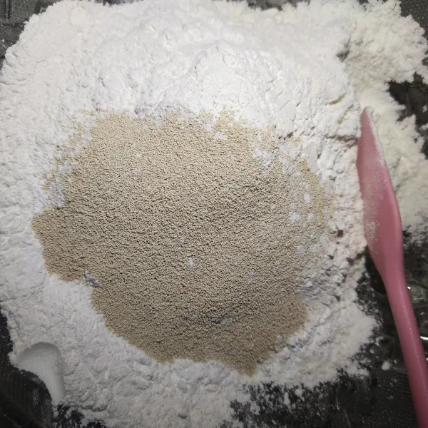 Langkah yang pertama, masukkan tepung terigu dan tepung ketan, gula halus beserta fernimpan. Aduk sampai rata.