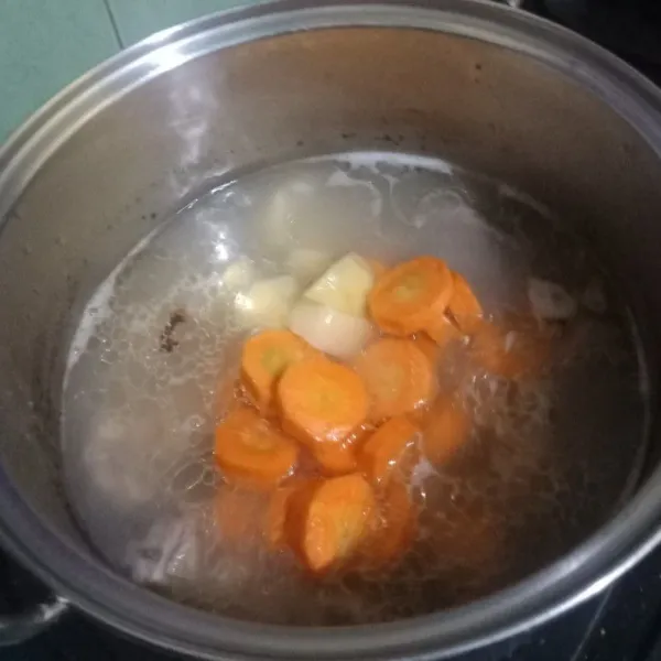 Masukan potongan wortel dan kentang, rebus hingga agak lunak.