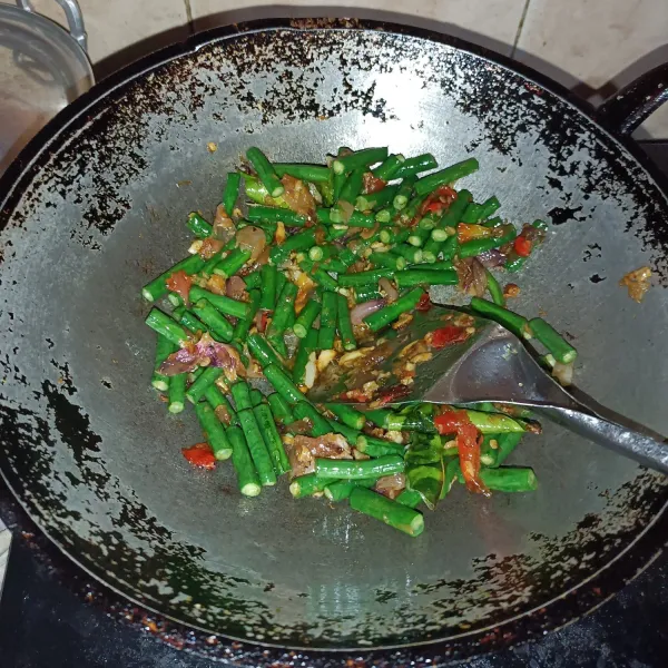 Tumis bumbu uleg sampai harum, lalu masukkan serai,daun salam,lengkus, dan daun jeruk,tumis sampai matang,masukkan kacang panjang tumis sampai agak lunak.