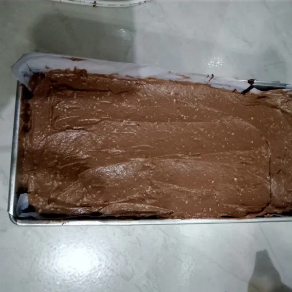 Tuang ke atas brownies, ratakan permukaannya. Simpan di dalam lemari es selama minimal 30 menit hingga lapisan set.