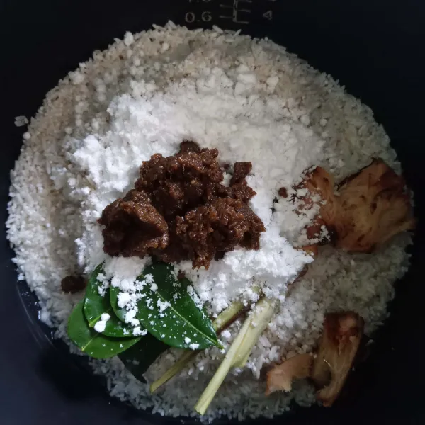 Masukkan santan bubuk dan bumbu Bamboe nasi uduk.