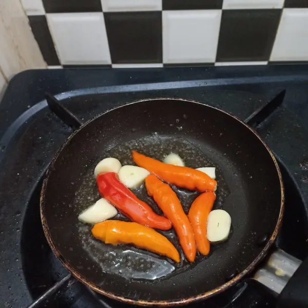 Goreng bahan sambal lalu ulek, sajikan di atas sate bersama tomat dan timun.