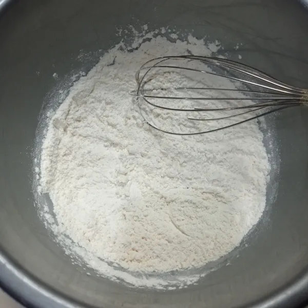 Ayak tepung terigu, baking powder, dan soda kue ke dalam wadah.