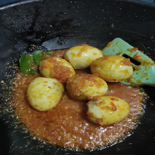 Jika rasa sudah sesuai, masukkan telur yang sudah digoreng tadi. Aduk rata, masak hingga bumbu mengental. Telur siap disajikan.