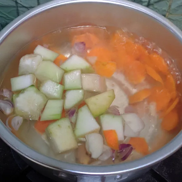 Dalam panci rebus air hingga mendidih, lalu masukan wortel, blonceng, bawang merah, bawang putih dan temu kunci. Masak hingga setengah empuk.
