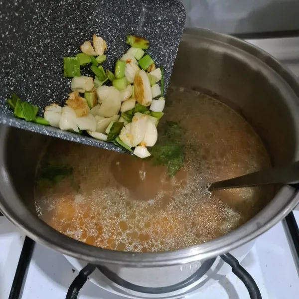Tumis bawang putih dan daun bawang hingga harum, lalu masukkan ke dalam panci sup ceker. Beri taburan bawang putih goreng.