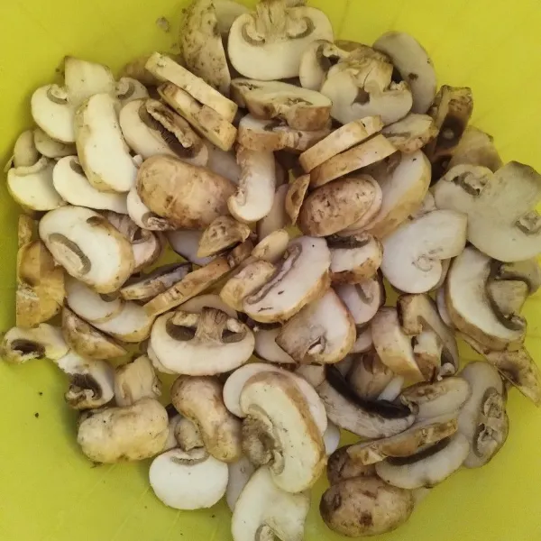 Cuci bersih jamur kancing, iris sesuai selera.