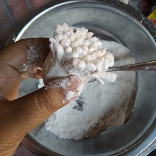 Aduk rata tepung terigu, tepung maizena dan kaldu bubuk, balurkan pada terong termasuk pada sela-sela irisan.