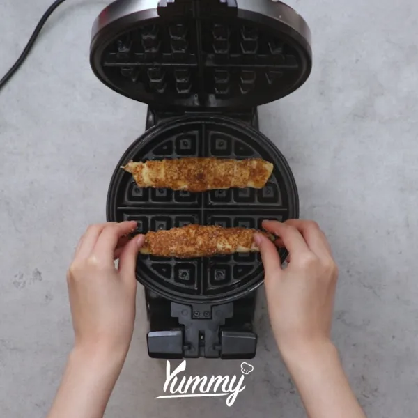 Panggang adonan di waffle machine.