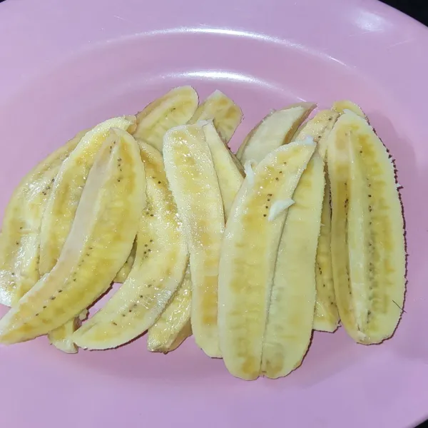 Selanjutnya belah setiap pisang menjadi 4 bagian.